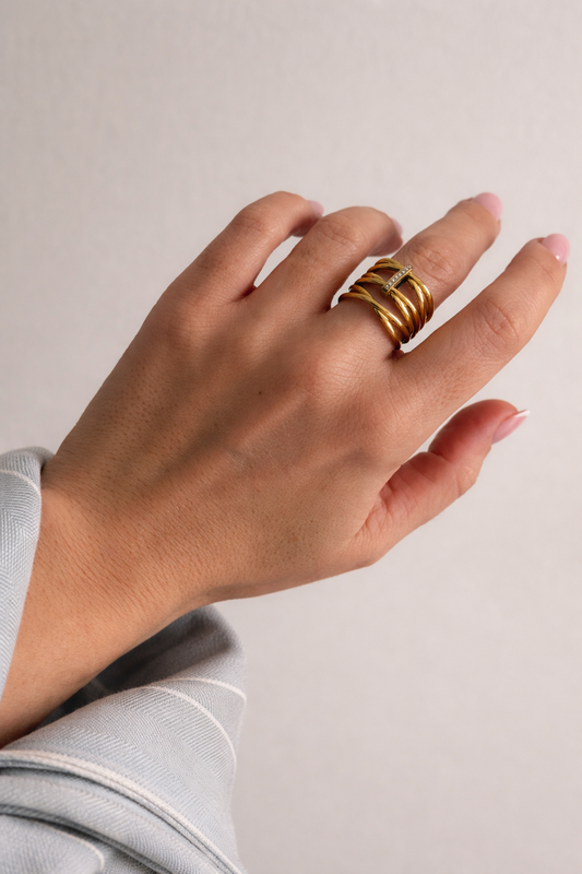 Prsten od nehrđajućeg čelika u zlatnoj boji. Ukrašen sitnim cirkonima.